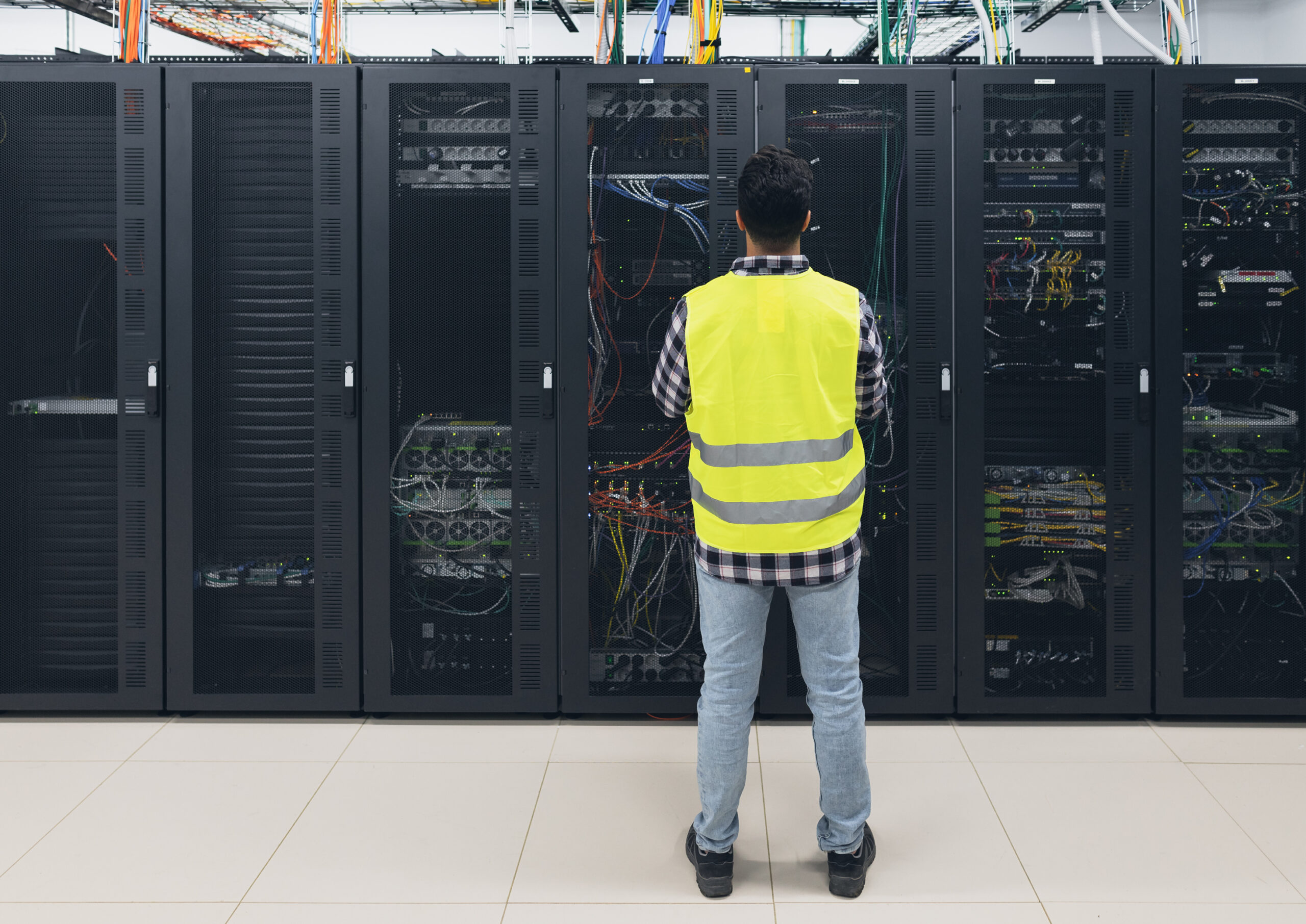 Male informatic engineer working inside server room database